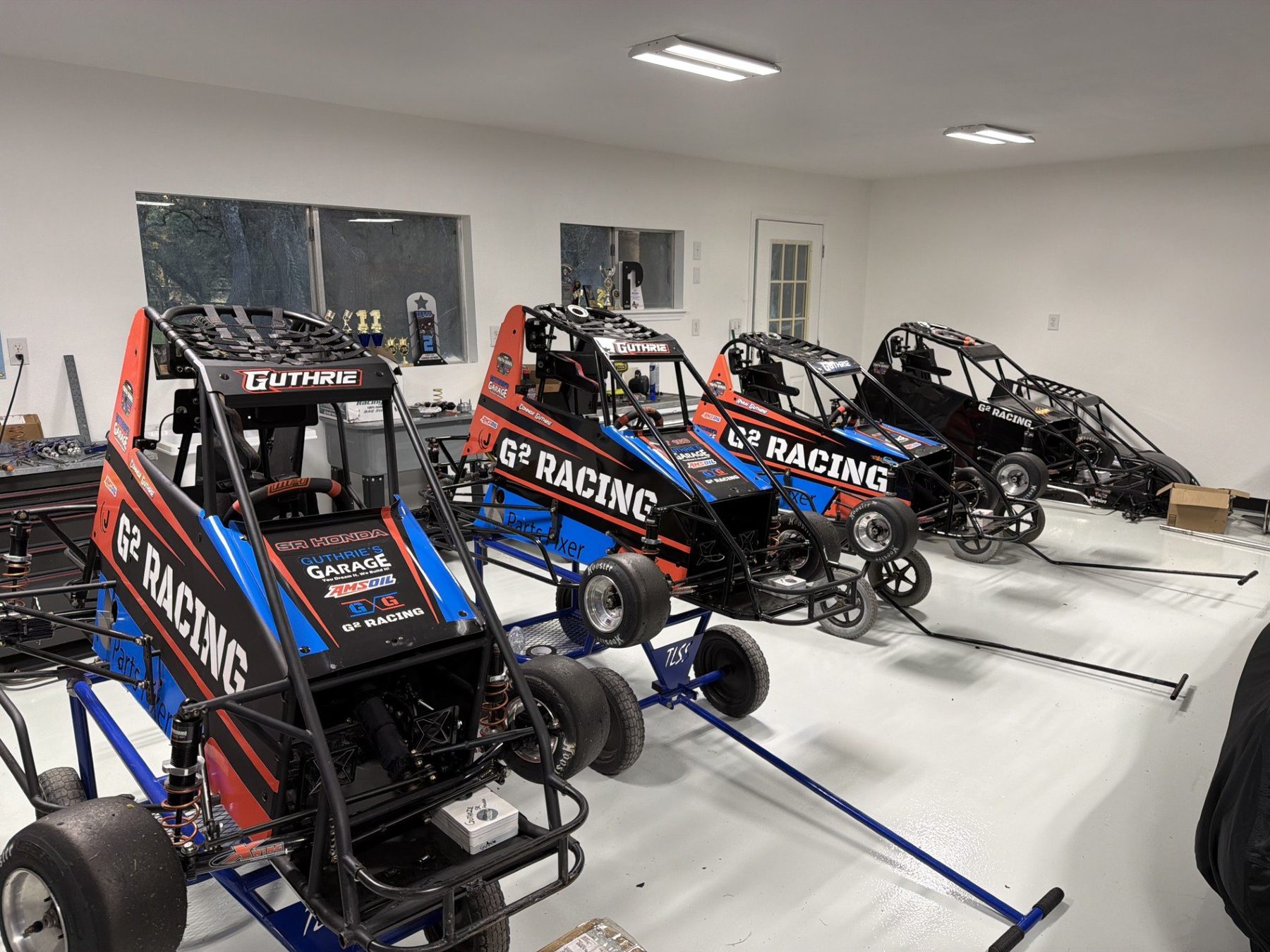 Four G² Racing quarter midgets lined up on the shop floor