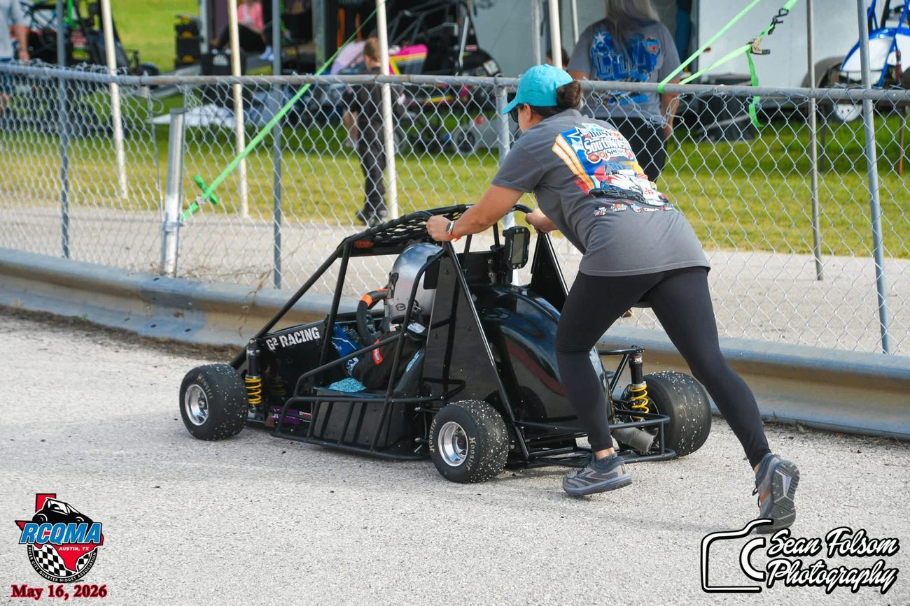 Jennifer Guthrie pushing a quarter midget away from the fence line