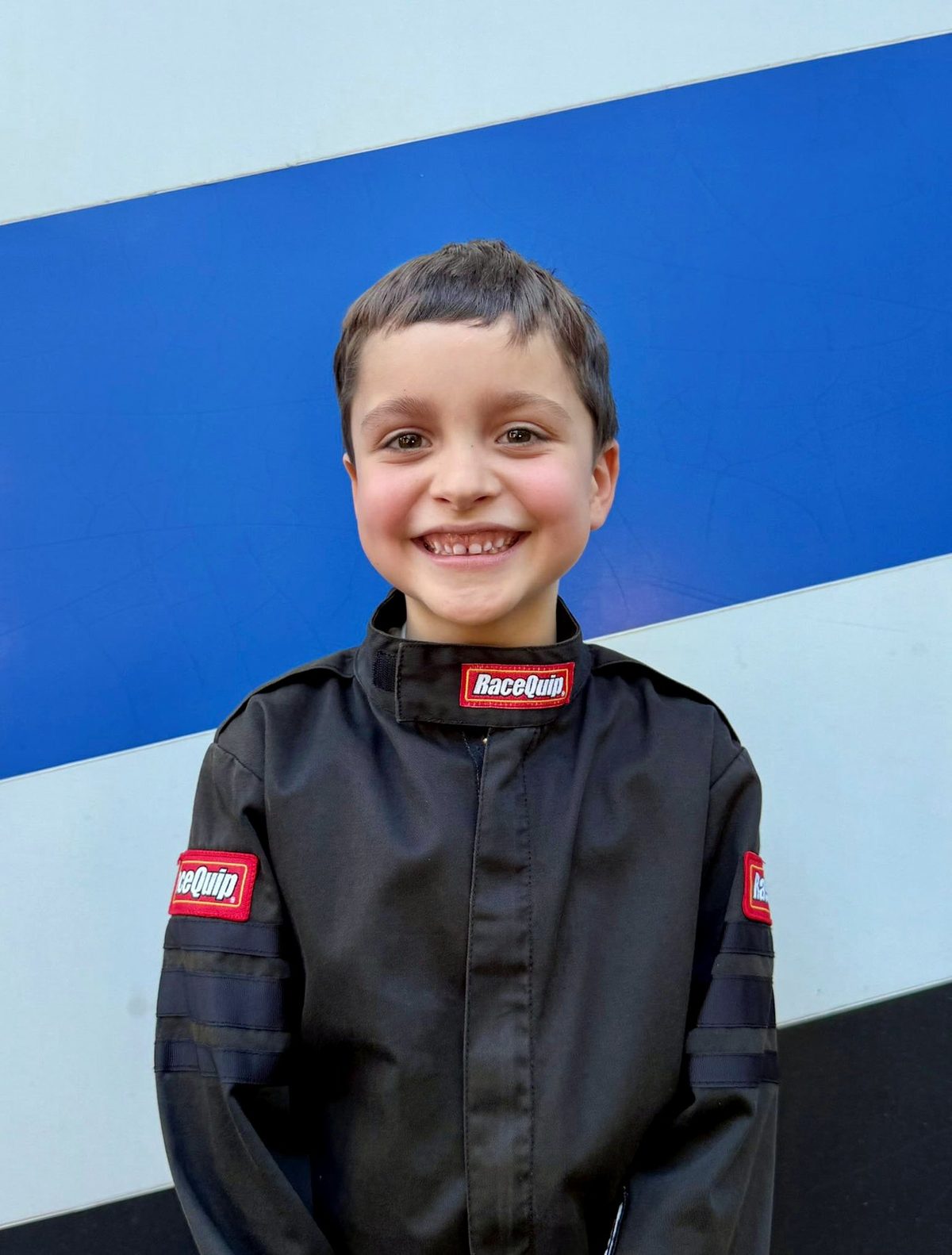Ryan Guthrie in his racing suit holding his helmet
