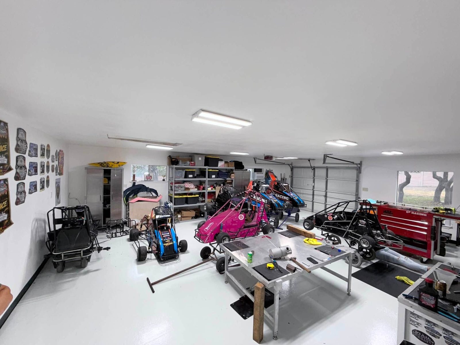 The G² Racing workshop with cars on stands and tools along the wall