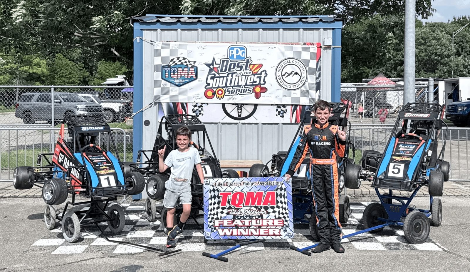 Connor and Ryan holding Tulsa feature winner signs
